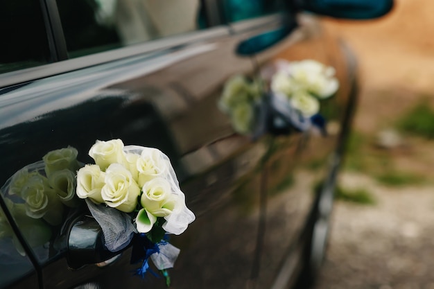 Luxe trouwauto versierd met bloemen