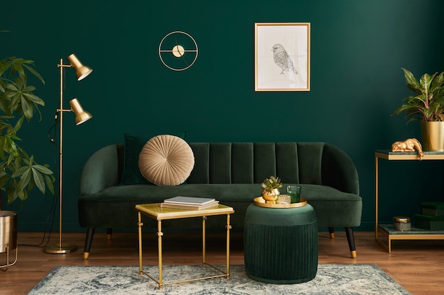 Luxe woonkamer in huis met modern interieur, groene fluwelen bank, salontafel, poef, gouden decoratie, plant, lamp, tapijt, frame en elegante accessoires.