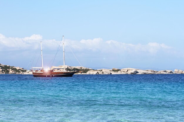 Luxe zeilschip afgemeerd in turquoise water zee van wild Sardinië eiland Retro zeiljacht in een prachtige baai van Sardinië in de Middellandse Zee Reizen en luxe lifestyle concept Wanderlust