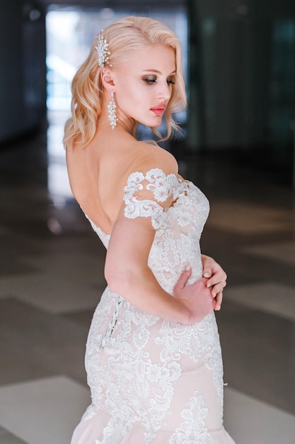 Luxurious blonde bride in offtheshoulder wedding dress posing for the camera