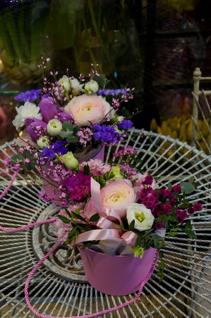 세련된 둥근 상자에 섬세한 라이트 핑크 라 난큐 라스가있는 고급스러운 꽃다발.