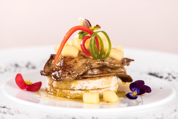 Luxurious dish with duck liver, pineapple and mango pieces, sweet sauce, placed on toasted