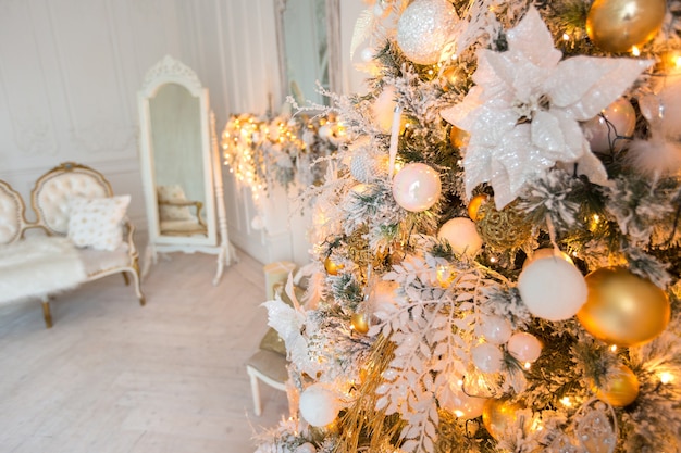 Lussuoso e costoso soggiorno interno luminoso in stile regale decorato con un albero di natale e ampie finestre