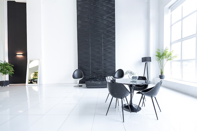 Luxurious futuristic trendy modern interior in contrasting black and white colors with interesting fashionable black furniture and decorated wall