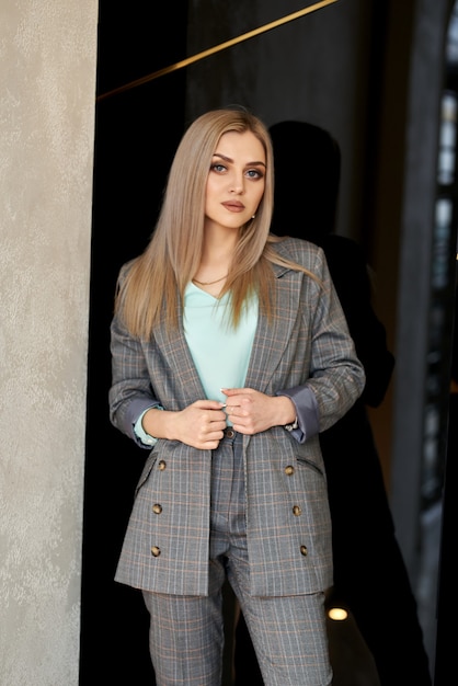 Photo luxurious girl posing in a business style in the hotel corridor.