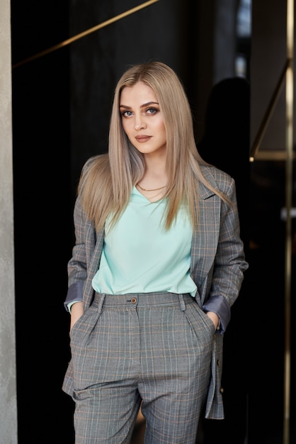 Luxurious girl posing in a business style in the hotel corridor.