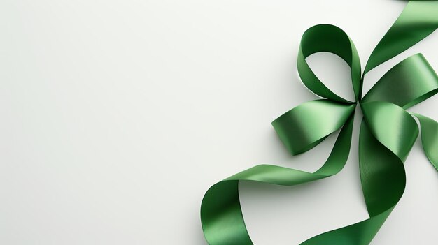 A luxurious green bow made of smooth satin on a white surface with space for customization