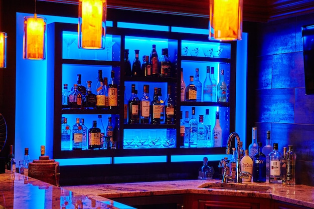 Photo luxurious home bar with blue lighting and marble top eyelevel view