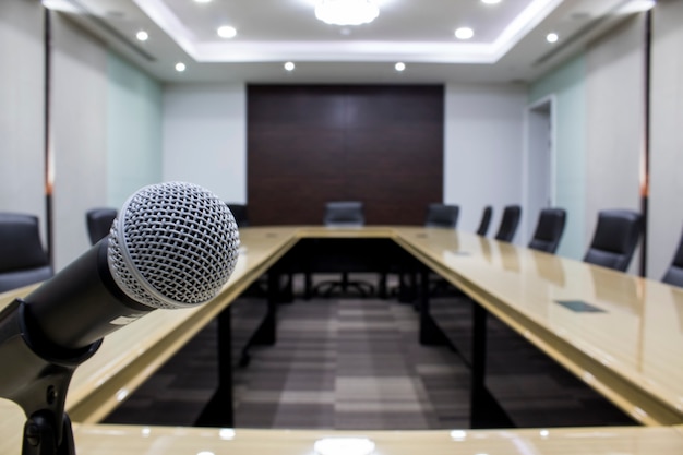 Роскошный конференц-зал в большой корпорации Микрофон и современный стол для заседаний совета директоров со стулом черного цвета.