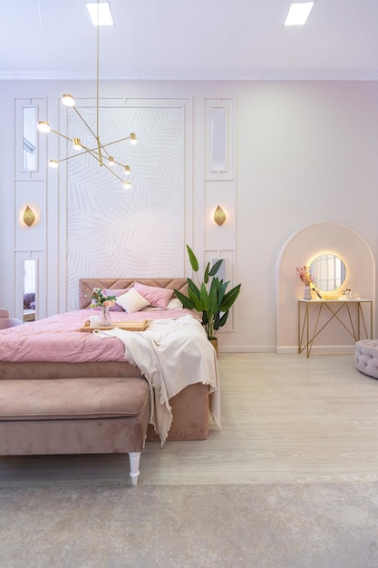 Luxurious modern bedroom interior of an expensive spacious light stylish apartment. upholstered furniture and decorative lighting, soft pastel colors and cozy atmosphere