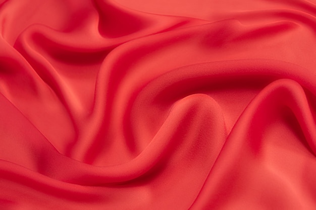 Luxurious red viscose or silk fabric. Background and pattern.