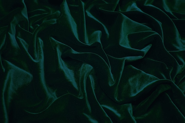 Photo luxurious velvet fabric in dark green. background and pattern.