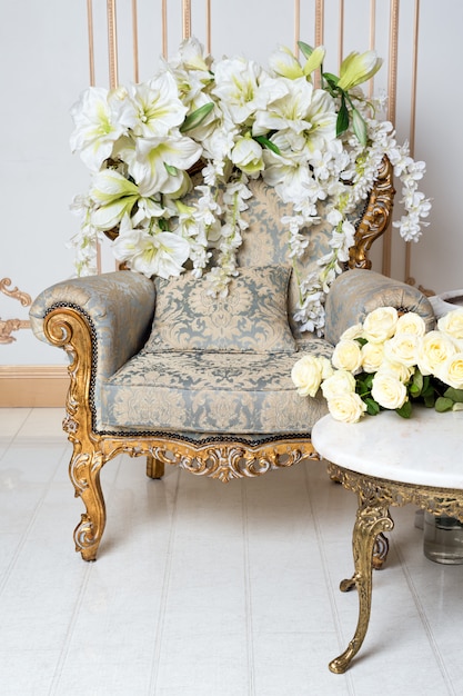 Роскошный винтажный интерьер в аристократическом стиле с элегантным креслом и цветами. Ретро, классика.