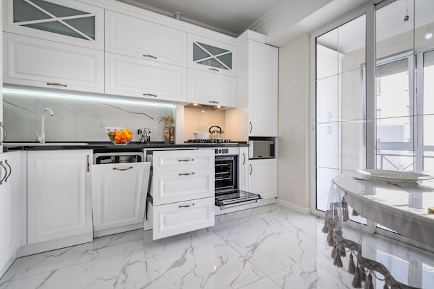 Luxurious white modern kitchen interior drawers pulled out and dishwashers door open