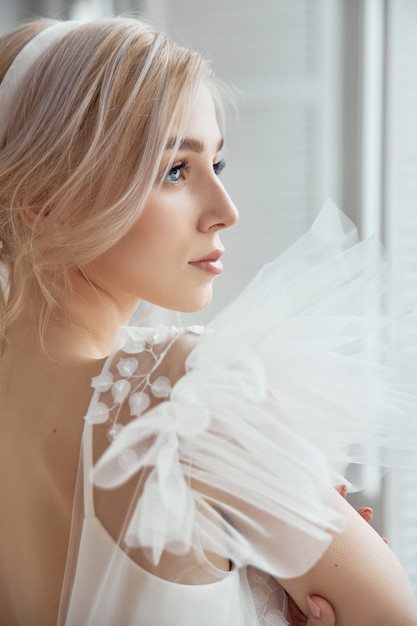 Lussuoso abito da sposa bianco sul corpo della ragazza. nuova collezione di abiti da sposa. mattina sposa, una donna che aspetta lo sposo prima della cerimonia di nozze. giovane sposa in un abito lungo