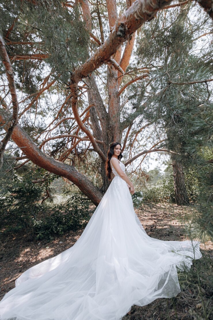 Photo 高価なファッショナブルなワードローブの豪華な若い花嫁は、高級リゾートの町での結婚式の写真撮影のためにポーズをとる