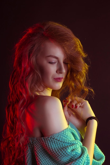 Luxurious young woman with curly hair in the shadows