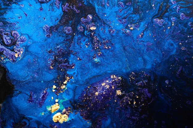 Фото Роскошный абстрактный фон, жидкое искусство, синие спиртовые чернила с золотыми пятнами краски, поверхность воды, мраморная текстура