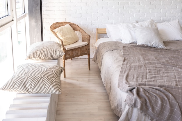 Luxury bedroom design in a rustic cottage in a minimalist style. white walls, panoramic windows, wooden elements of decoration on the ceiling, rope swings in the middle of a spacious room.