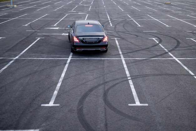 Luxury black car on a parking lot view from above Business transfer serfice concept and transportation concept