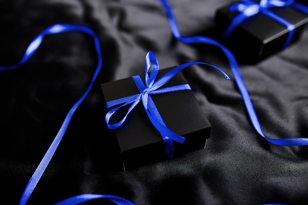 Photo luxury black gift boxes with blue ribbon