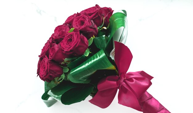 Luxury bouquet of burgundy roses on marble background beautiful flowers as holiday love present on Valentines Day