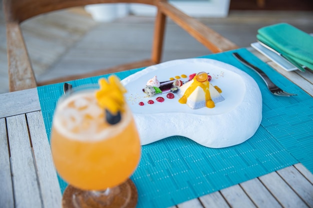 Luxury breakfast food fresh juice on wooden table with beautiful tropical resort sunrise sea sky
