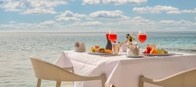 白いテーブル、美しい熱帯の海の景色の背景、朝の夏の時間の豪華な朝食の食べ物