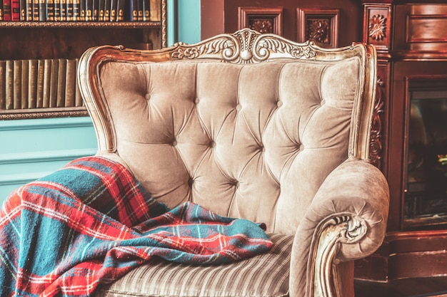 Фото Роскошный классический интерьер домашней библиотеки. гостиная с книжной полкой, книгами, креслом, диваном и камином