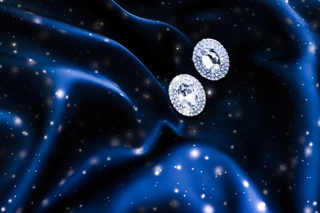 Luxury diamond earrings on dark blue silk with snow glitter holiday winter magic jewelery present