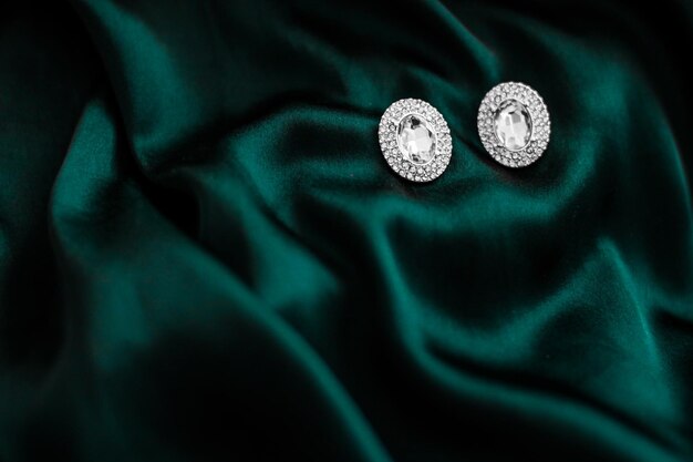 Luxury diamond earrings on dark emerald green silk holiday glamour jewelery present