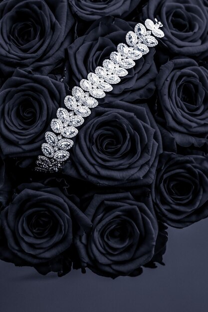 高級ダイヤモンド ジュエリー ブレスレットと黒いバラの花は、バレンタインデーとジュエリー ブランドの休日の背景デザインのギフトが大好き