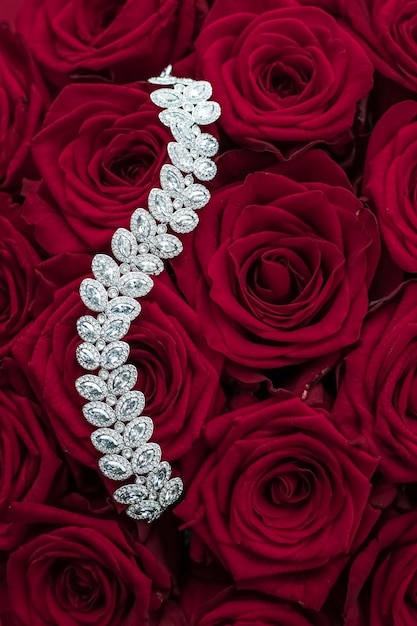 고급 다이아몬드 보석 팔찌와 빨간 장미 꽃은 발렌타인 데이 선물과 보석 브랜드 휴일 배경 디자인을 좋아합니다.