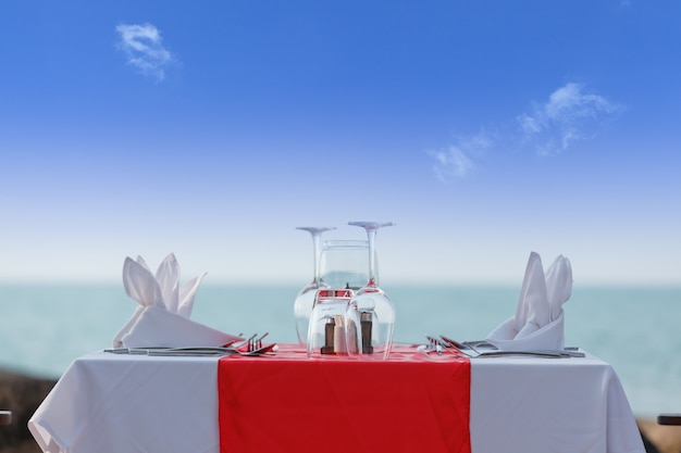 Tavolo da pranzo di lusso sulla spiaggia nel cielo blu