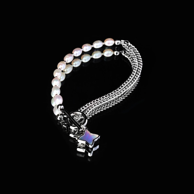 Luxury elegant baroque pearl silver bracelet on black mirror background With reflection xACloseup shot Selective focus