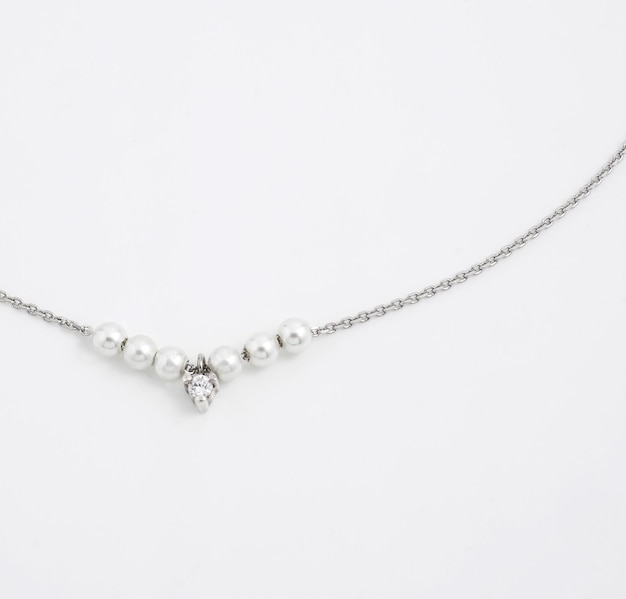 Luxury elegant silver chain with pearl pendant isolated on white background Top view