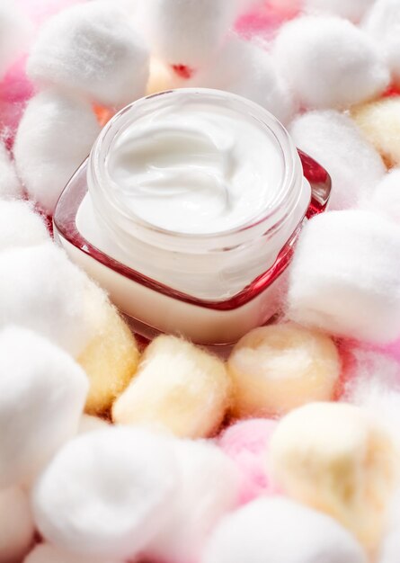 Foto crema viso di lusso per pelli sensibili e batuffoli di cotone ecologico su cosmetici spa di fondo e prodotti di marca di bellezza per la cura della pelle naturale