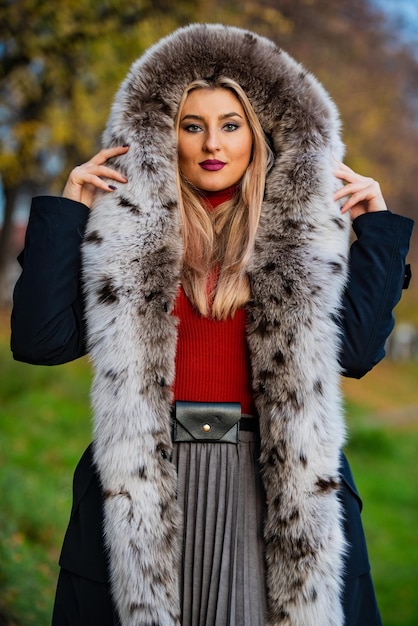 Luxury fur. Beauty and fashion. Woman wear coat with huge furry hood. Fake fur fabric. Elegant girl walk in autumn park. Fur garments. Really warm and cozy. Expensive clothes. Luxury segment brand.