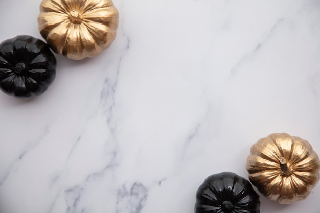Luxury gold and black autumn pumpkin flat lay composition on a marble background