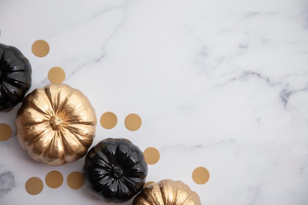 Luxury gold and black autumn pumpkin flat lay composition on a marble background