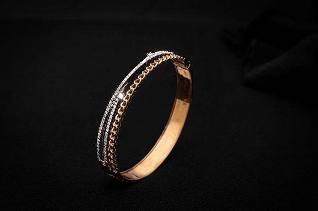 Foto fondo nero del braccialetto della mano del diamante dell'oro di lusso
