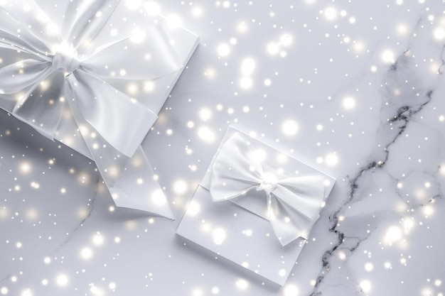 Luxury holiday gifts with white silk bow and ribbons on marble background Christmas time surprise