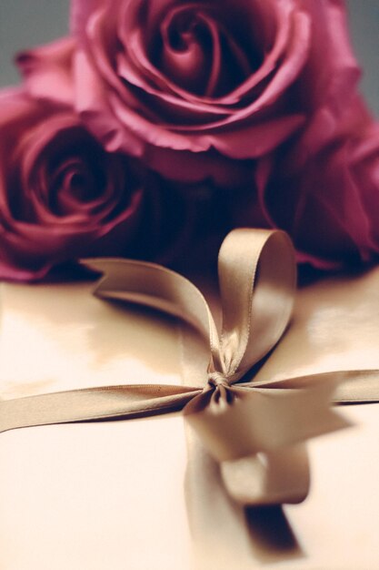 Luxury holiday golden gift box and bouquet of roses as Christmas Valentines Day or birthday present