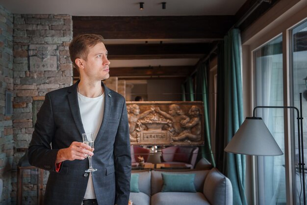 Luxury hotel scene with man in dark suit holding glass zermatt switzerland