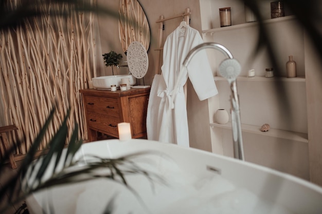 Foto lussuoso interno di un grande bagno in stile africano moderno con vasca da bagno ovale in illuminazione naturale