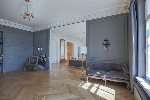 Luxury interior of a spacious apartment in an old 19th century historical house with modern furniture. high ceiling and walls are decorated with stucco