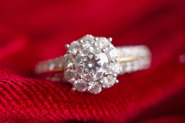 Роскошное ювелирное кольцо с бриллиантом на фоне красной ткани