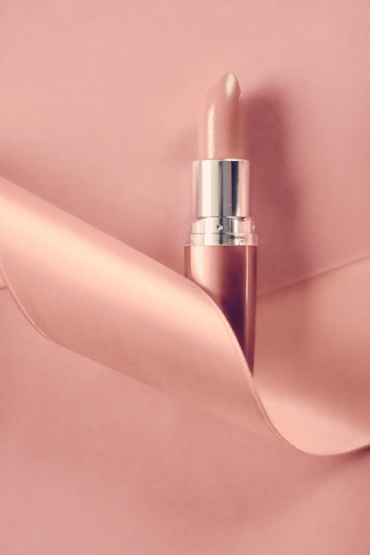 luxury lipstick and silk ribbon on blush pink holiday background makeup and cosmetics flatlay for beauty brand product design