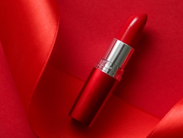 luxury lipstick and silk ribbon on red holiday background makeup and cosmetics flatlay for beauty brand product design