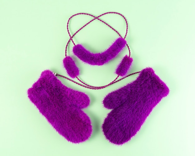 Luxury pink fur mittens on green